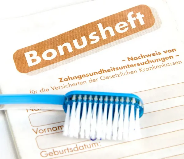 blaue Zahnb&uuml;rste die auf einem Bonusheft liegt
